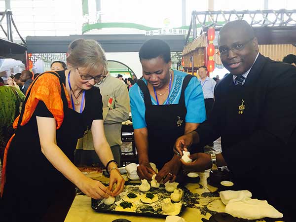 Foreign delegates to the food festival attend a session on making Yangzhou steamed buns.(Photo by Liu Zhihua)