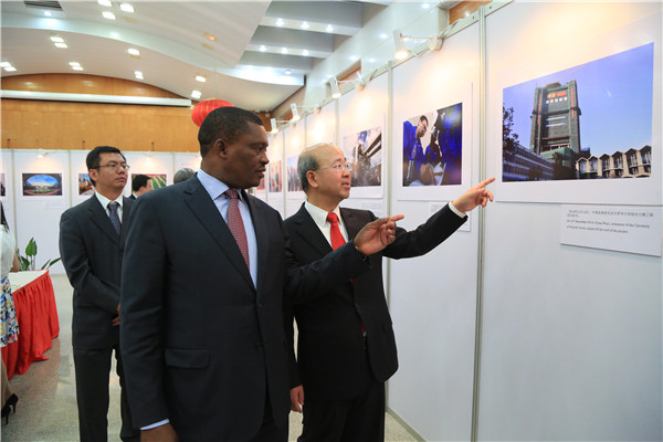 Chinese Ambassador Liu Xianfa (right) explains a picture to Justin Muturi, the speaker of Kenya's National Assembly. at a photo exhibition that was held at the same time as the reception for the 66th anniversary of the founding of the People's Republic of China. Hou Liqiang / China Daily