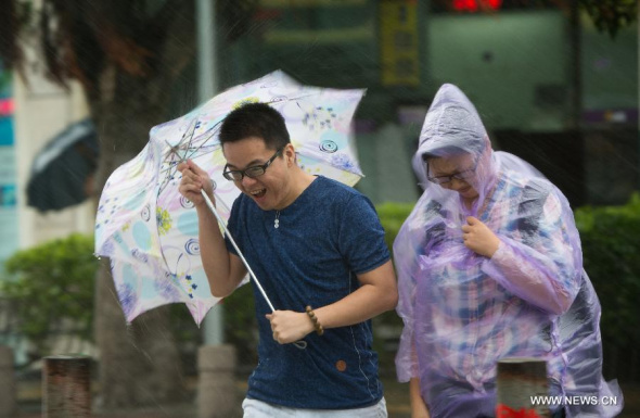 People walk in rainstorm in Xiamen, a coastal city in southeast China's Fujian Province, Sept. 29, 2015. Typhoon Dujuan, the 21st typhoon this year, made landfall in the province on Tuesday morning. (Photo: Xinhua/Jiang Kehong) 