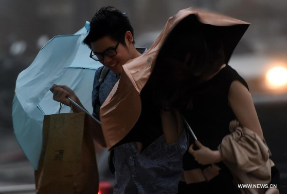 Pedestrians walk in the street against the wind in Taipei, southeast China's Taiwan, Sept. 28, 2015. Typhoon Dujuan made landfall in Yilan County of Taiwan at 5:40 p.m. Monday, bringing strong winds. (Photo: Xinhua/Han Yuqing)
