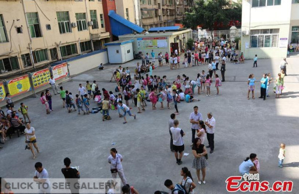 Students who should have studied in classrooms chat on a playground of a primary school in Bazhong, Southwest China's Sichuan province on first day of school, September 6, 2015. (Photo/CFP)