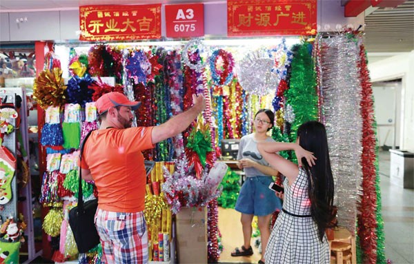 A businessman (L) selects products in Yiwu for sale at Christmas. Made in China gives Americans a Merry Christmas. (Photo/China Daily)