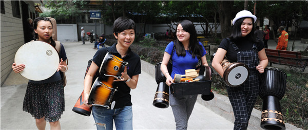 Music therapist Wang Lujie (second from left) and her colleagues are on their way to a session in Chengdu, Sichuan province. YU PING/CHINA DAILY