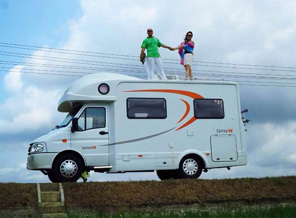 A retired couple from Qingdao, Shandong province, on the roof of their motor home during a tour of Hainan province.  (Liu Hailong / For China Daily)