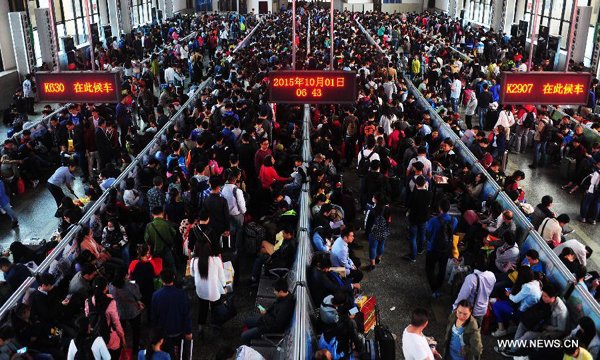 Passengers queue to board trains at the railway station of Zhengzhou, capital of central China's Henan Province, Oct 1, 2015. A travel peak is seen in Zhengzhou on Thursday, the first day of the National Day holidays which spans from Oct 1 to 7. (Photo/Xinhua)