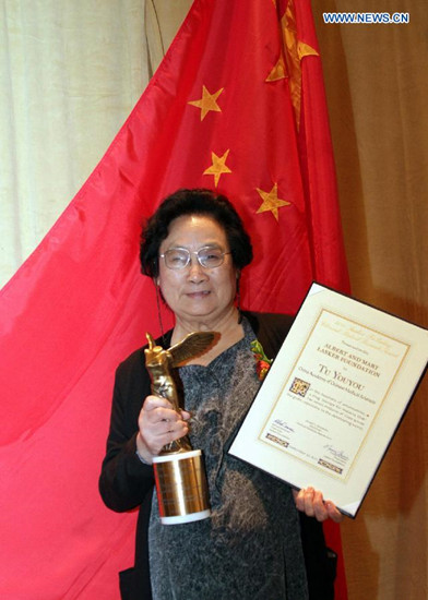 File photo taken on Sept. 23, 2011 shows Chinese Pharmacologist Tu Youyou posing with her trophy after winning the Lasker Award, a prestigious U.S. award, in New York, the United States. China's Tu Youyou, Irish-born William Campbell, and Japan's Satoshi Omura jointly won the 2015 Nobel Prize for Physiology or Medicine, the Nobel Assembly at Sweden's Karolinska Institute announced on Monday.(Xinhua/Wang Chengyun)