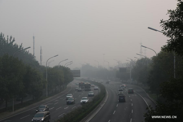 Vehicles run in smog in Beijing, capital of China, Oct. 6, 2015. China's central observatory on Tuesday issued a yellow alert for smog to hit parts of north China, including Beijing, on Tuesday and Wednesday. (Photo: Xinhua/Liu Xianguo)