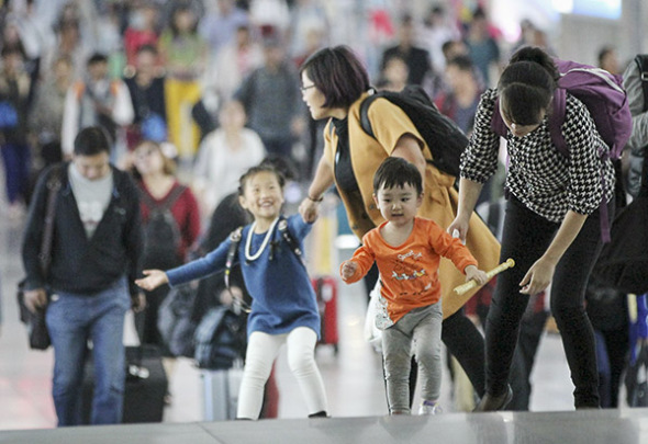 Tourists exit Qingdao Railway Station in Shandong province on Monday. (Photo: China Daily/HUANG JIEXIAN)