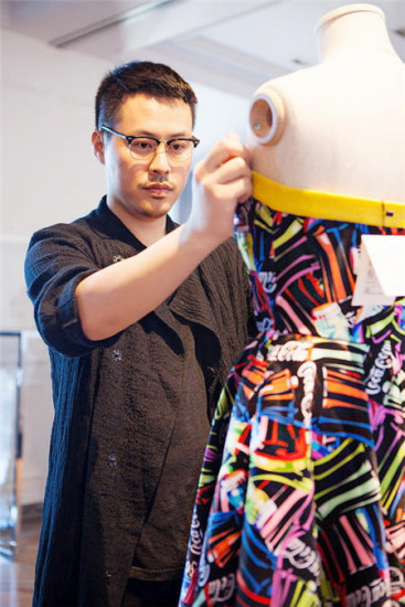 Christopher Bu works on the collection featuring jackets, skirts and dresses, inspired by Coca-Cola's logos, shapes and palette. (Photo provided to China Daily)