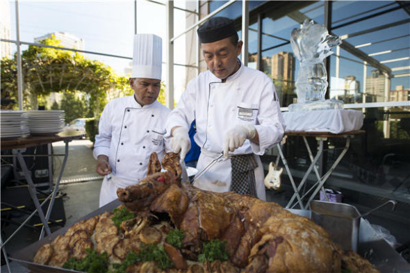 Chefs wow the opening-night crowd with a roast suckling pig made specially for the occasion. (Photo/Provided To China Daily)