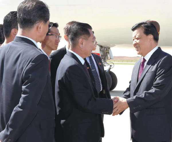 Liu Yunshan (right), a member of the Standing Committee of the Political Bureau of the CPC Central Committee, is greeted in Pyongyang on Friday. Liu will attend activities marking the anniversary of the Workers' Party of Korea. (Photo by RAO AIMIN/XINHUA)