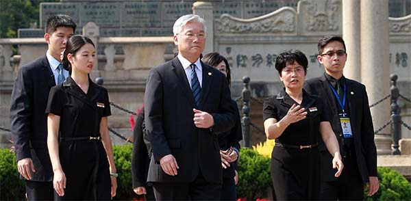 Taiwan's mainland affairs chief, Andrew Hsia, visits the Huanghuagang Mausoleum of the 72 Martyrs in Guangzhou on Wednesday during a trip for a meeting on allowing mainland air passengers to transfer in Taiwan. (Photo: China Daily/Zou Hong)