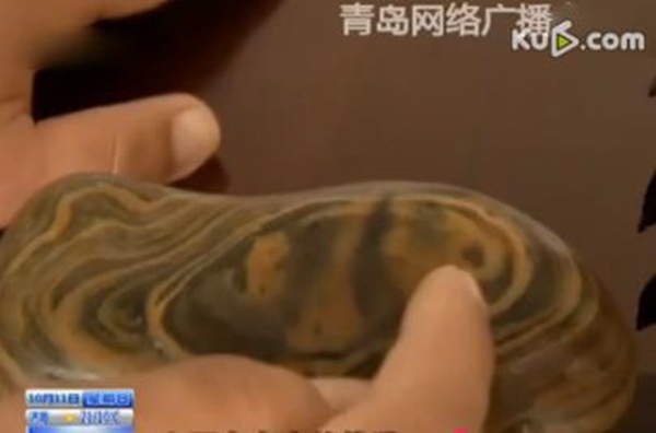 The panda stone Lin found seems to bear an image of China's iconic bear. (Screenshot form Qingdao Network Radio and TV Station)