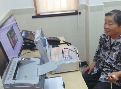 A senior uses a machine to monitor bone density at a community activity center in Lujiazui sub-district in Shanghai. Provided to China Daily