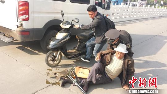 An urban management officer helps an old man to stand up. (File photo/Chinanews.com)