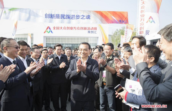 Chinese Premier LiKeqiang (C) inspects the exhibition of mass entrepreneurship and innovation week in Beijing, capital of China, Oct. 19, 2015. The mass entrepreneurship and innovation week kicked off on Monday incities including Beijing, Shanghai, Shenzhen, Wuhan, Xi'an,Chengdu, Hefei and Shenyang. (Photo: Xinhua/Huang Jingwen)