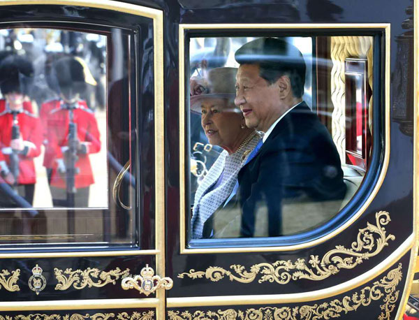 Britain's Queen Elizabeth and Chinese President Xi Jinping are driven by carriage along The Mall to Buckingham Palace in London Oct 20, 2015. (Wu Zhiyi/China Daily)