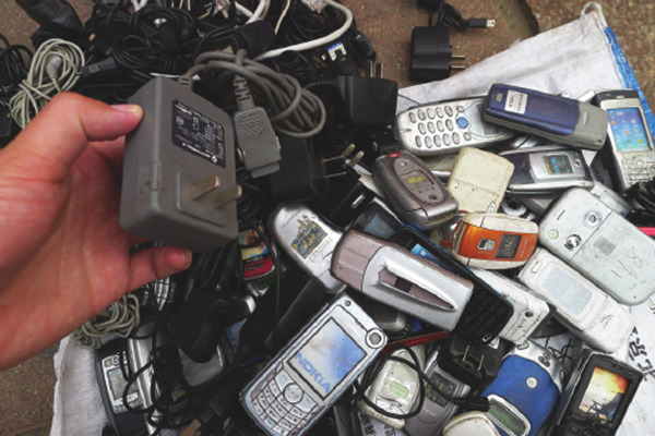 Piles of discarded mobile phones and chargers collected by a recycling vendor in Qingdao, Shandong province. (Photo/China Daily])