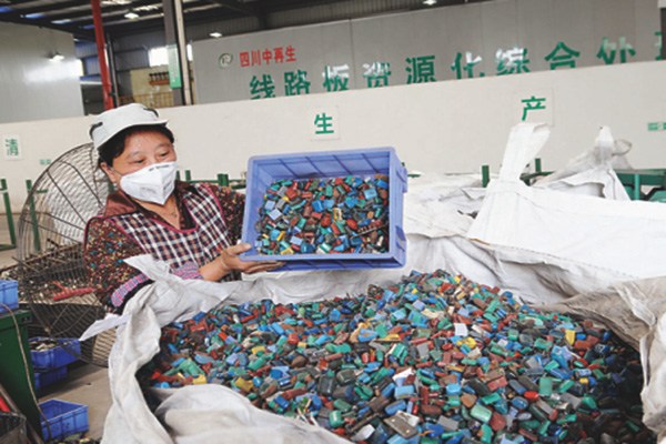 A worker packs the electronic waste after dismantling at one of the recycling processing plants in southwest China. (Photo/China Daily)