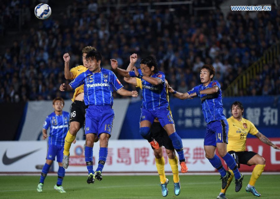 Huang Bowen (16, in yellow) of China's Guangzhou Evergrande heads the ball during the AFC Champions League semi-final match betweenJapan's Gamba Osaka and Guangzhou Evergrande in Osaka, Japan, Oct. 21, 2015. (Photo: Xinhua/Liu Dawei)