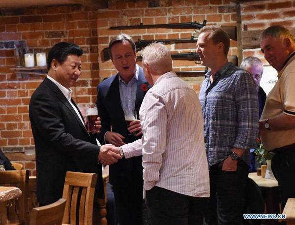 Chinese President Xi Jinping (1st L) and British Prime Minister David Cameron (2nd L) talk with local people at a pub after their meeting in Cameron's country retreat, Chequers, Britain, Oct. 22, 2015. (Photo: Xinhua/Rao Aimin)