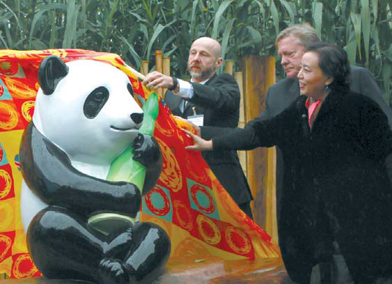 Wang Yihua, chairwoman of Ronshin Group (right), Paul Bailey, business manager of the Association of Leading Visitor Attractions (center), and Mark Waterstone, director of China Building Technique Group & Guildhouse Rosepride LLP, unveil Ming's statue at London Zoo on Oct 21. Tuo Yannan / China Daily