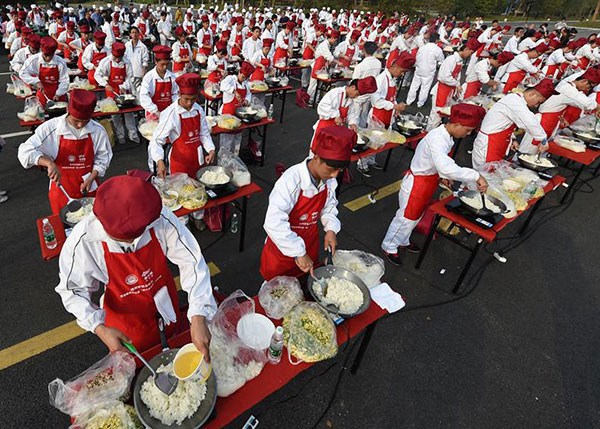 Four tons of fried rice is no problem for 300 cooks simultaneously cooking in Jiangsu province on Thursday. (Photo/Xinhua)
