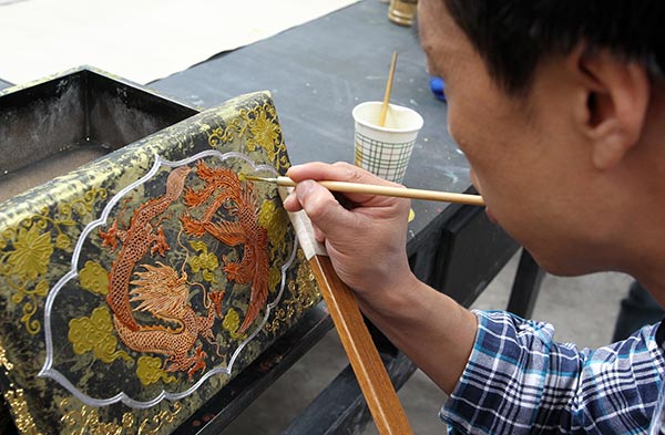 An artist works with paints. (Photo by Xu Lin/China Daily)