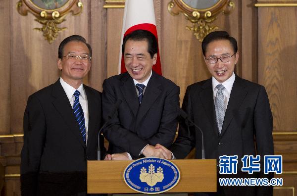 Then Premier Wen Jiabao (left), then Japanese Prime Minister Naoto Kan (center), and then President of the Republic of Korea Lee Myung-bak shake hands at a press conference during the 4th China-Japan-ROK trilateral summit in Tokyo, May 22, 2011. (Photo/Xinhua)