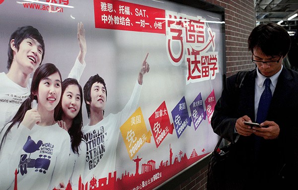 A man walks past an advertisement for an English-language tutorial agency in the Beijing subway. (Wang Zhuangfei/China Daily)