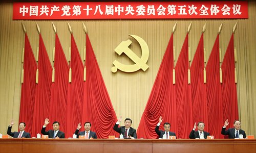 Leaders of the Communist Party of China led by Xi Jinping (center) raise their hands at the fifth plenary session of the 18th CPC Central Committee as the four-day annual meeting concluded in Beijing on Thursday. (Photo/Xinhua)