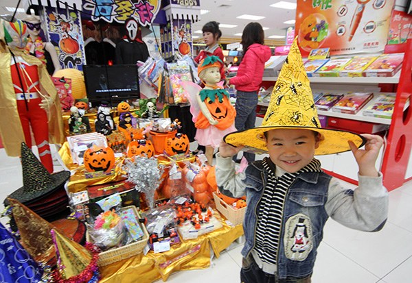 A child tries on a hat for Halloween in a shopping mall in Beijing. Retailers are finding a new gold mine in the niche market for Halloween costumes in China. (Photo/China Daily)