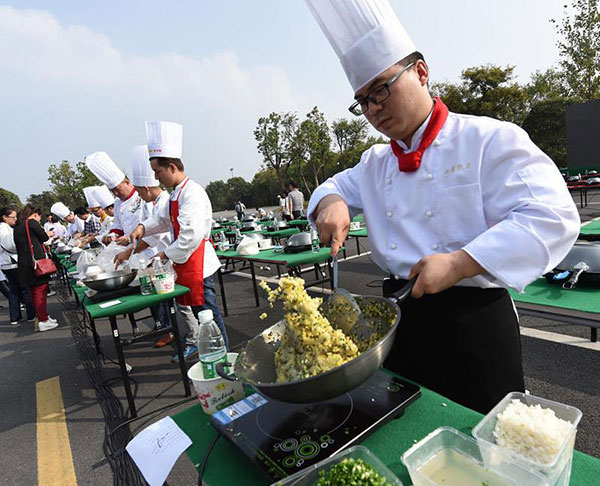 A cook stirs a pan of fried rice. (Photo/Xinhua)
