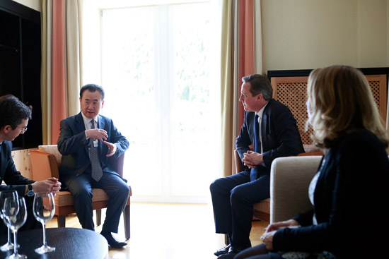 Wang Jianlin, chairman of Dalian Wanda Group, talks to UK Prime Minister David Cameron on Jan 24, 2014 in Davos, Switzerland. (Photo / Provided to chinadaily.com.cn)