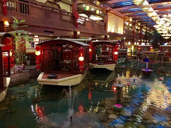 Xiaoxiang Jiayu Cun restaurant's dinner tables are replicas of small covered boats creating an illusion of dining at lakeside. (Photo:China Daily/ Mike Peters)