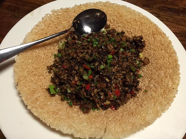 A Hunan taco with stir-fried pork, onion, garlic and herbs piled on a cracker. (Photo:China Daily/Mike Peters)