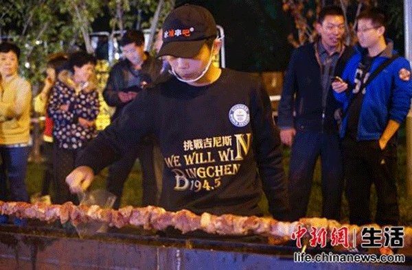 A chef barbecues the meat on a grill. (Photo/Chinanews.com)