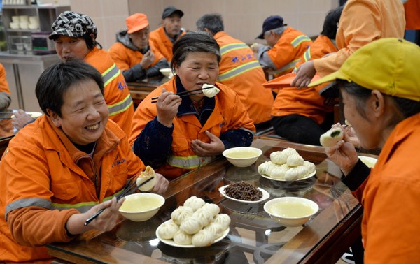 Sanitation workers enjoy free meals at a restaurant in Handan, Hebei province, on Tuesday. The restaurant provided the meals to nearly 100 workers to call on society to care more about the laborers. HAO QUNYING/CHINA DAILY