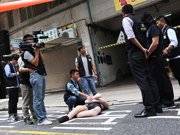 Police reconstruct the scene of a crime after an incident at a store in Hong Kong when a tourist from the mainland was allegedly beaten unconscious by four men while mediating in a shopping dispute. The victim died the next day.(Photo provided to China Daily)