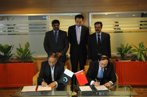 Chinese Ambassador to Pakistan Sun Weidong (R, front) and Pakistani Information Minster Pervez Rashid (L, front) sign a transfer certificate in Islamabad, capital of Pakistan, Nov. 5, 2015. (Photo: Xinhua/Ahmad Kamal)