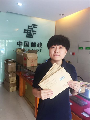 Ma Hu holds letters she is going to send to the authorities to call for the end of a labor regulation that she believes discriminates against women. (Photo: Courtesy of Ma Hu)