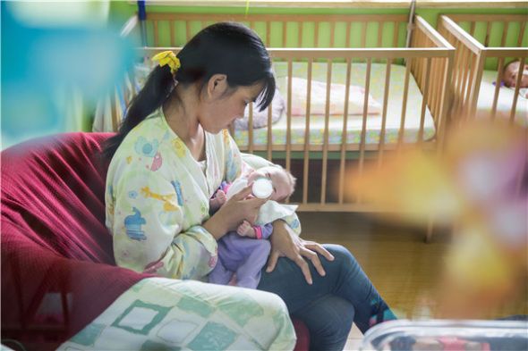 'Kangaroo mother' feeding a premature infant. (Photo: China Daily/Han Jiwei)