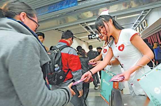 An AIDS control worker distributes free condoms to passengers in a subway in Wuhan, Hubei province, last year. Shi Ji / China Daily