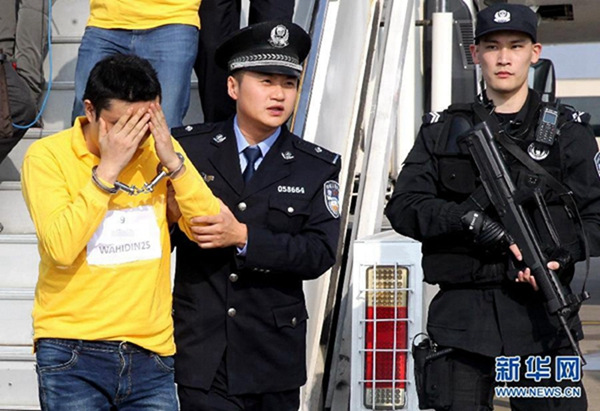 Suspects involved in telecom swindle cases are escorted off an aircraft by the police at Pudong International Airport in Shanghai, Nov 10, 2015. (Photo/Xinhua)