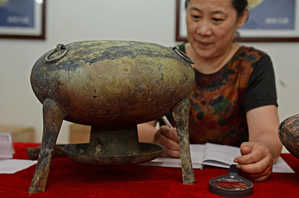 A three-legged bronze, unearthed in the 2,000-year-old tomb of Haihunhou in Nanchang, Jiangxi province, may be a hot pot.(Wan Xiang/Xinhua)
