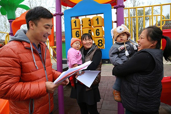 A family planning worker introduces the country's latest proposal of allowing all couples to have two children among villagers in Gu'an county, Hebei province, on Monday. (Photo/Xinhua)