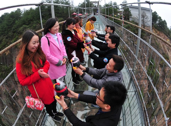 Marriage is proposed on an elevated walkway at Shiniuzhai Geological Park, Pingjiang, Hunan province, on Wednesday. XU XING/CHINA DAILY