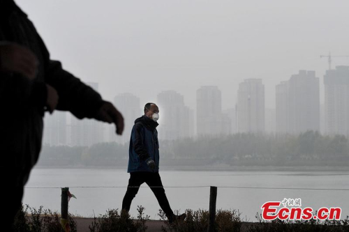 People walk on smog-enveloped road in Shenyang, capital of northeast China's Liaoning Province, Nov. 11, 2015. (CNS photo/Sun Haosheng)