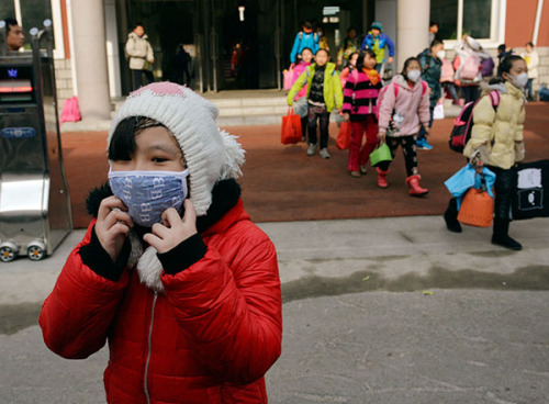 Primary school students in Shenyang, Liaoning province, wear masks to protect themselves from pollution on Friday. The city has seen severe smog for several days. (Photo/China Daily)