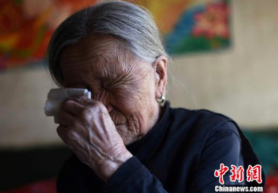 Zhang Xiantu wipes tears with a handkerchief at her home in Xiyanxi village, Yangquan city, North China's Shanxi province. (Photo/chinanews.com)